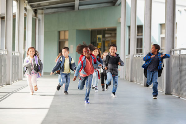 elementary-school-kids-running-in-a-corridor-in-1920 elementary kids running down hall