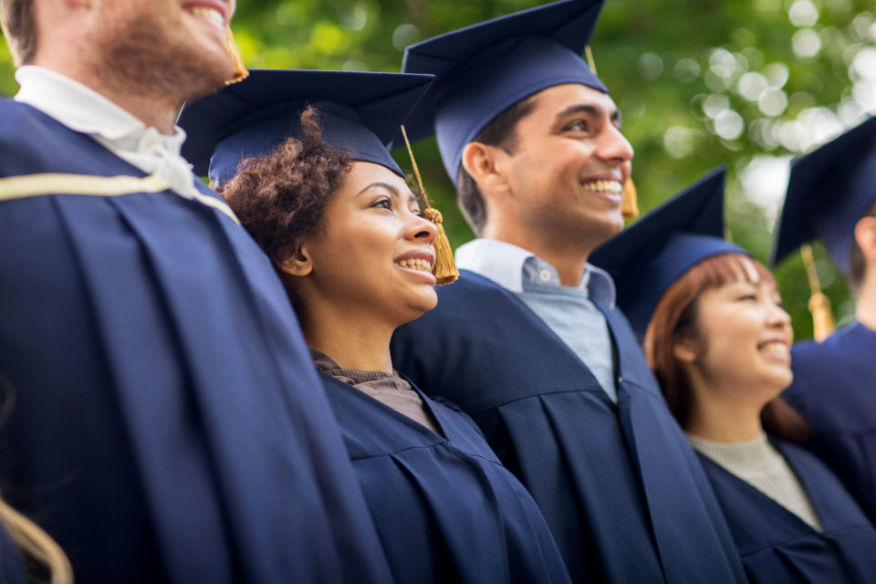 smiling students in caps and gowns